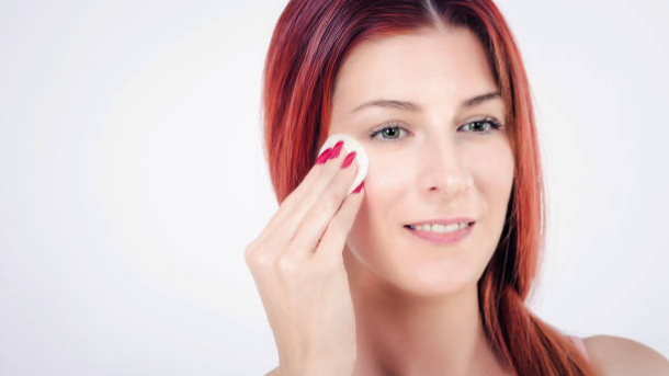 Woman applying foundation to cover redness without green concealer